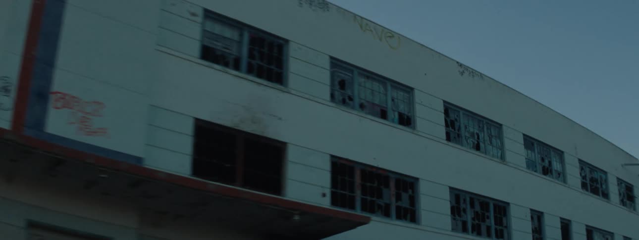 Close up of the facade of a small building on a town at morning seen from a moving vehicle