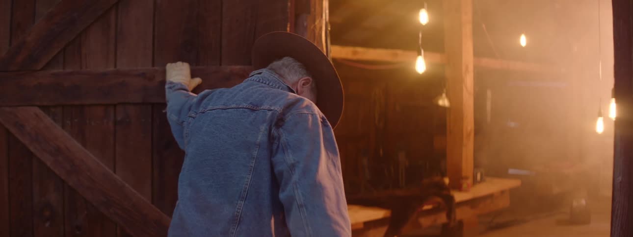 A man is walking into a barn on his farm