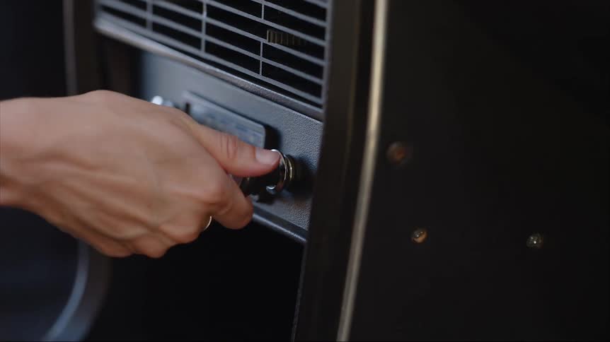 A person is adjusting the radio volume in a car