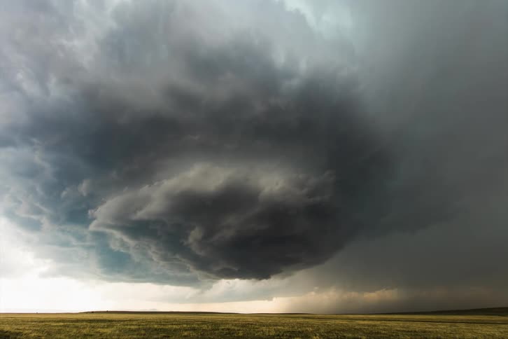 A huge menacing storm cloud swirls around as lightning strikes within it