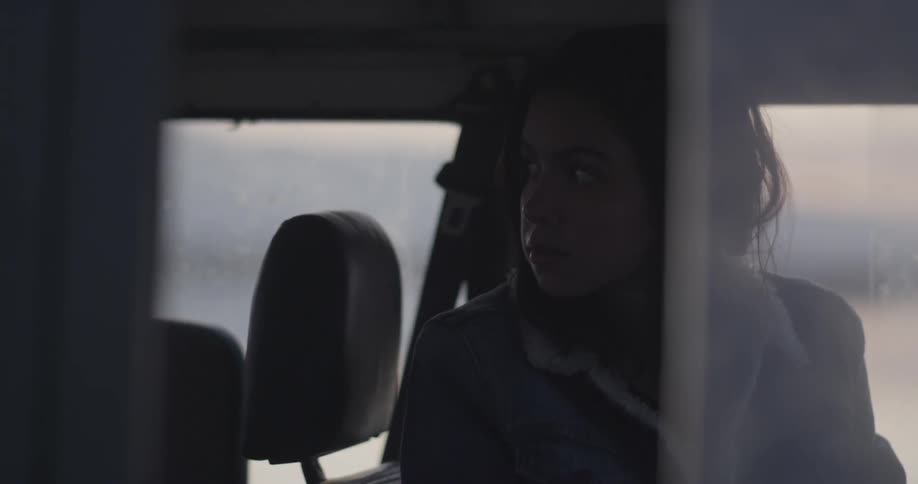 A woman looks back sitting in a vehicle