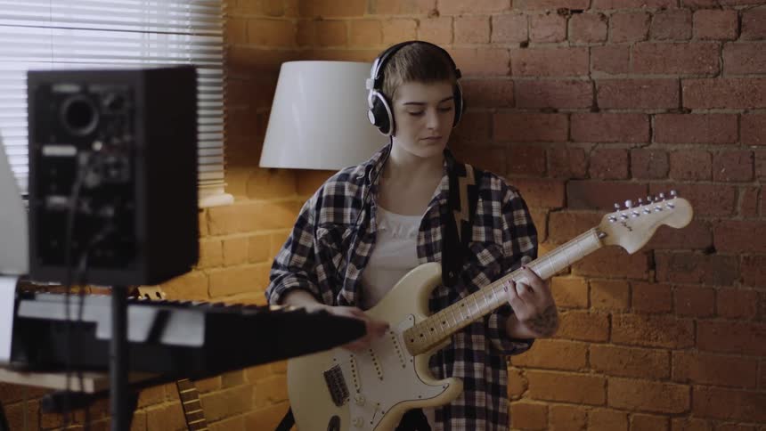 A woman is playing her guitar