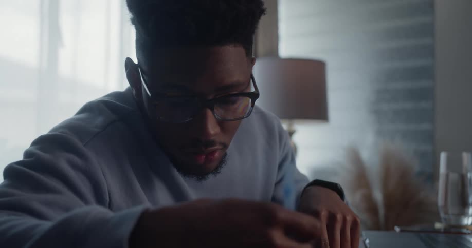 A man uses his laptop while doing homework