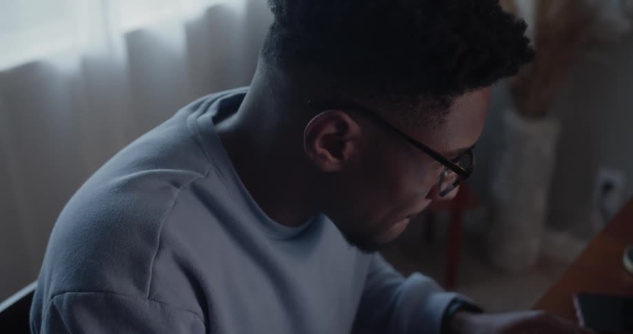A young man concentrates has he types on a laptop computer keyboard