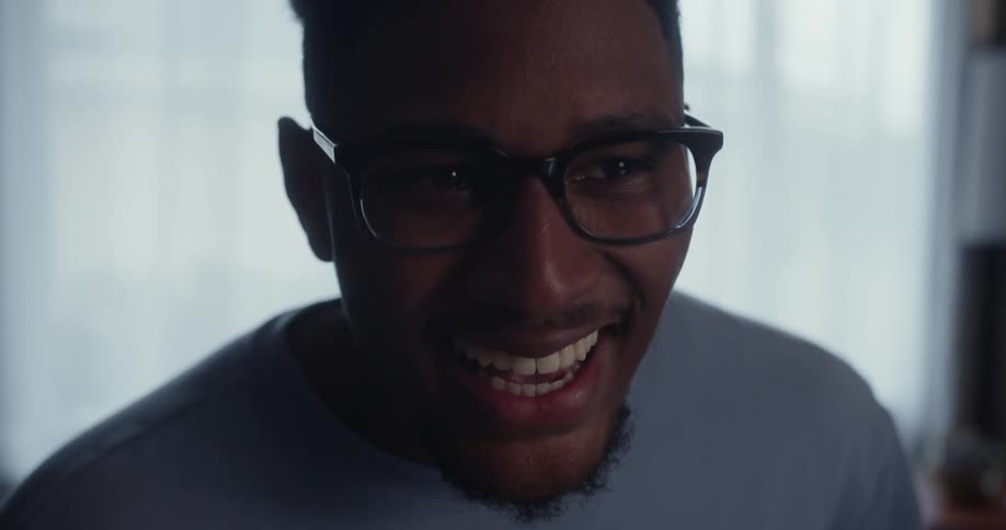 A man smiles and talks while using a calculator