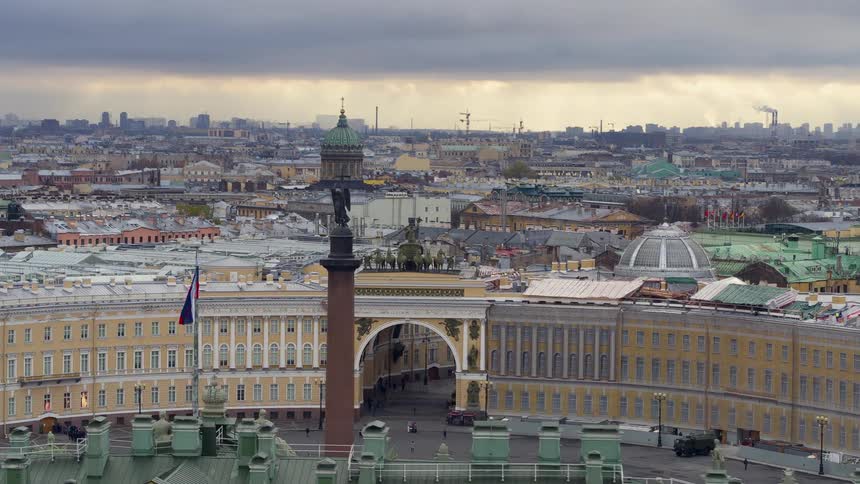 Angel statues overlook a crowded city filled with beautiful architecture as people move through an arched building