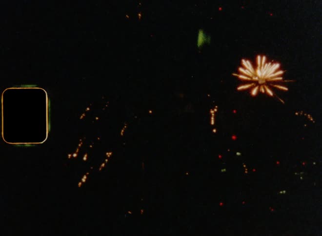 Numerous fireworks explode and sparkle in the sky at night