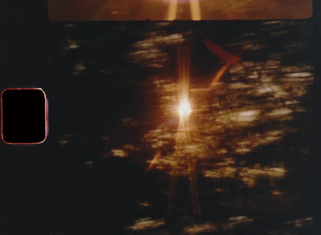 The vintage Super 8mm camera races or moves at high-speed as the sun shines brightly behind a row of trees creating bright lens flares with flickering light and dynamic energetic movement for fast transitions