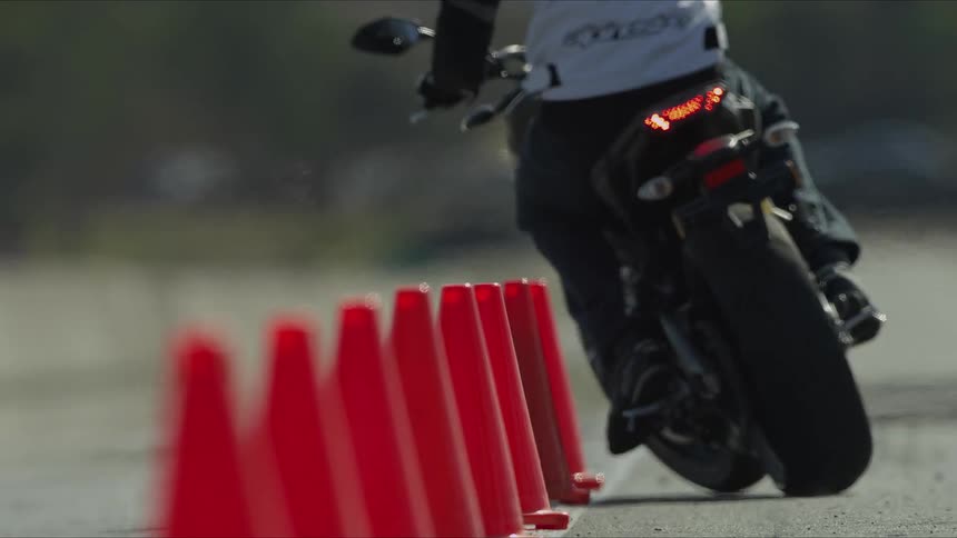 A motorcyclist rides between traffic cones set up on a track