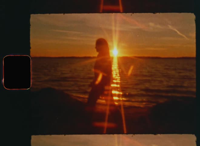 Peaceful scene of a Caucasian girl with long brown hair walking alone without shoes by the beach at the ocean enjoying the sound of waves crashing and the fresh breeze of the sea as the sunrays shine from the rear on a warm summer evening