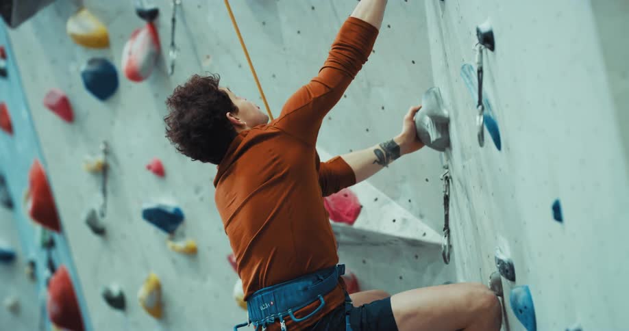 A man is rock climbing on a wall