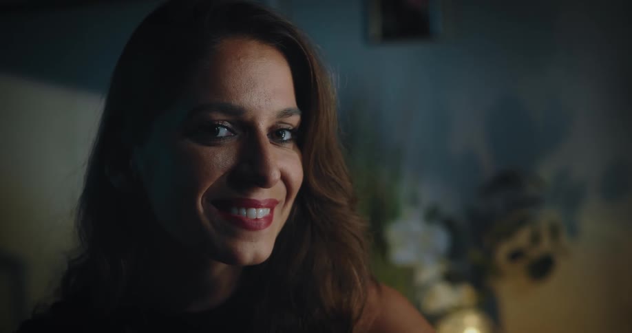 Woman with brown hair wears makeup and smiles at camera