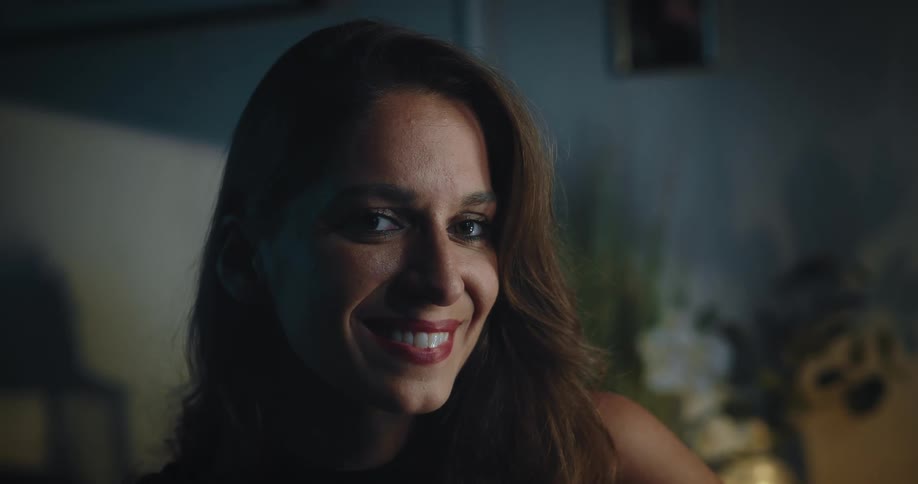 An up close of a womans face smiling and looking to the left