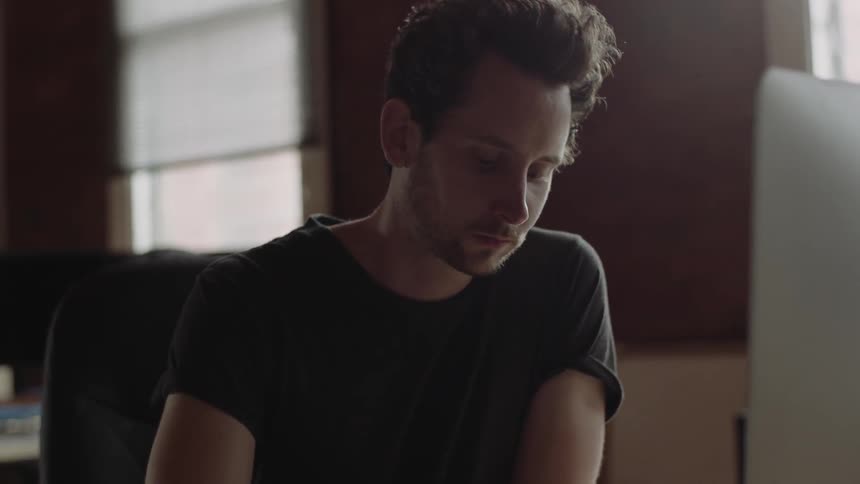 A man is typing on a keyboard looking forward