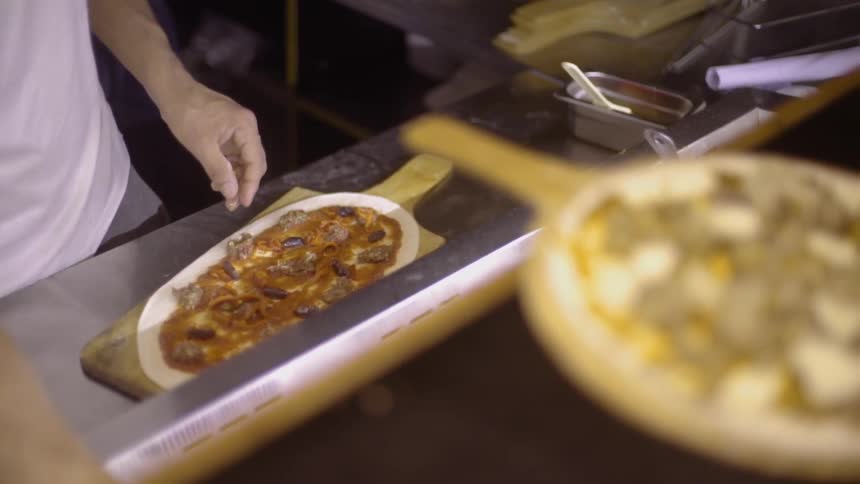 A man is making a pizza