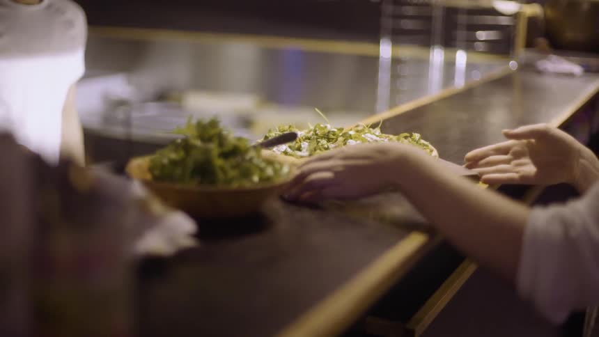A person picks up a salad and pizza