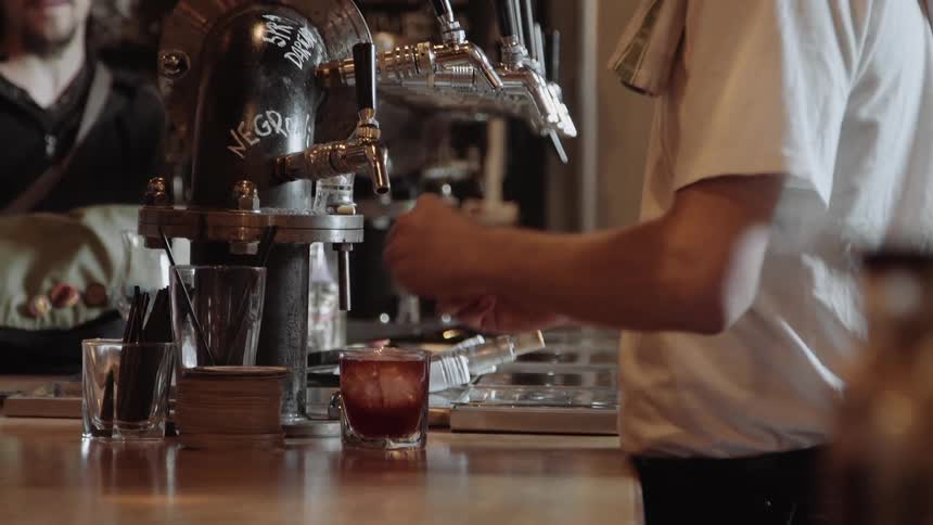 A person makes and serves a drink