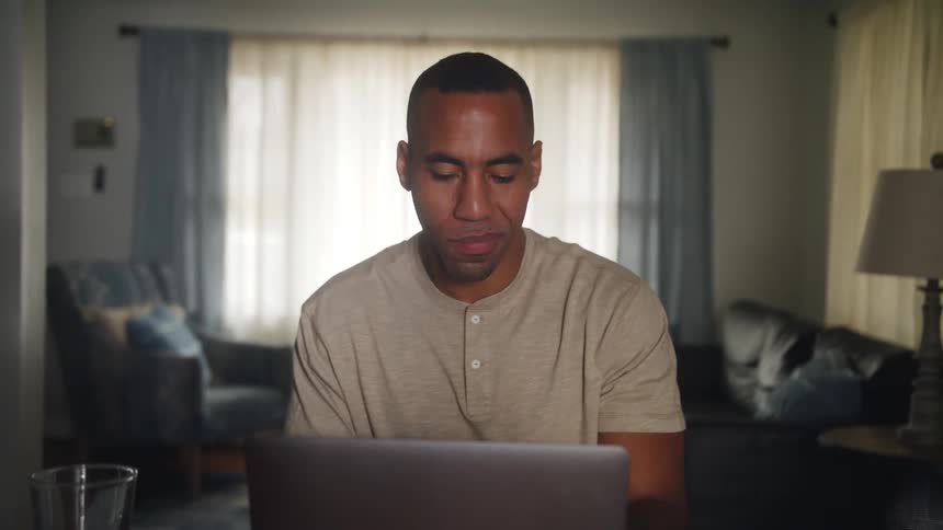 A man talks to someone while using his laptop