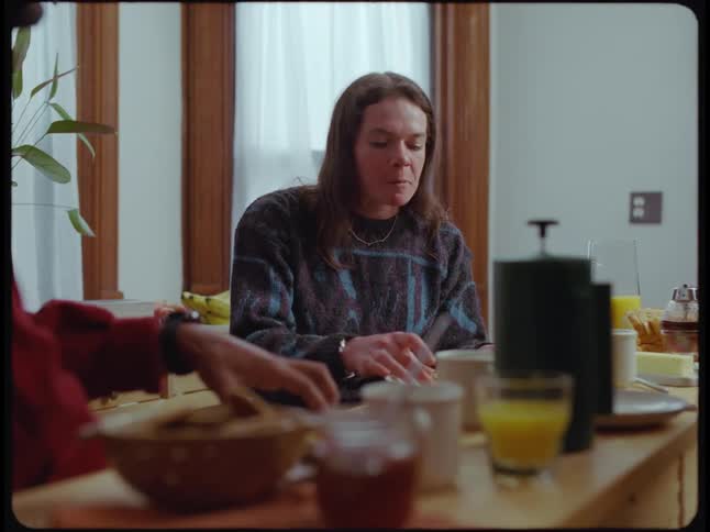 Woman talks with man then eats when another woman serves food for them