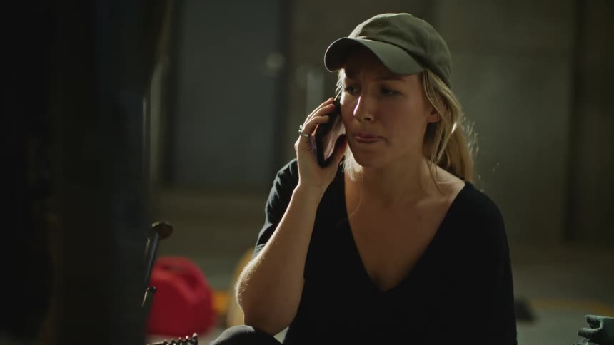 Woman talks on smartphone while working on frame