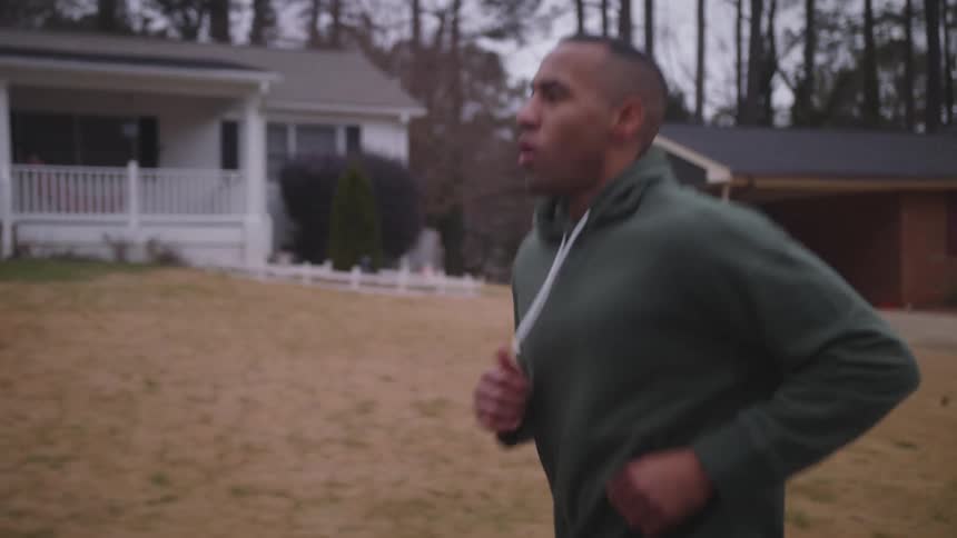 A man is jogging past the homes