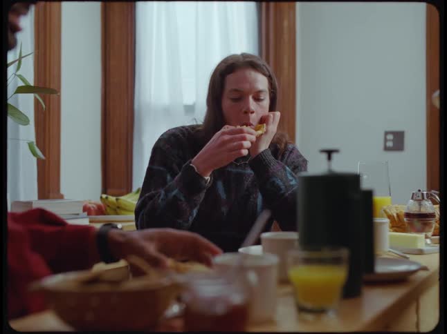 Friends chat while eating breakfast at home