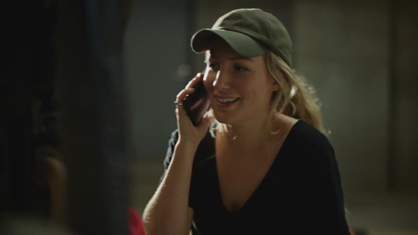 A woman is standing outdoors and talking on her phone