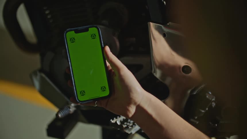 Nearby reflective surface reflects arm as woman views smartphone screen