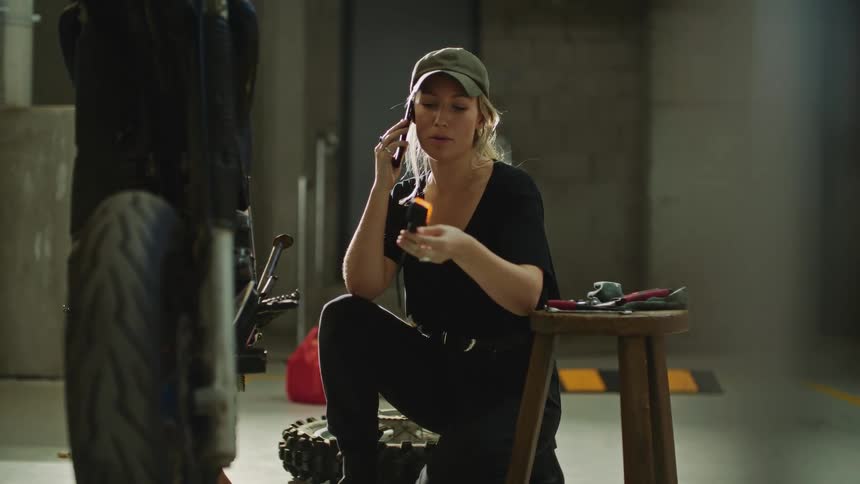 A woman is talking on her cellphone in a garage