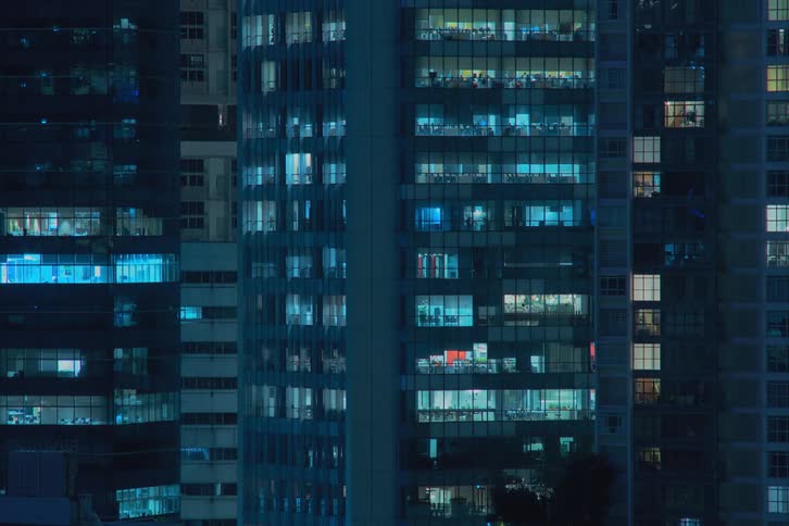 Time lapse of apartment buildings with flickering lights from the windows