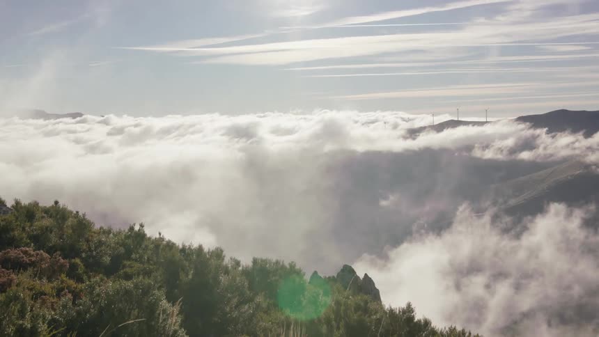 Clouds roll over a valley during the day