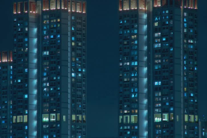 Time lapse of apartment buildings with flickering lights from the windows