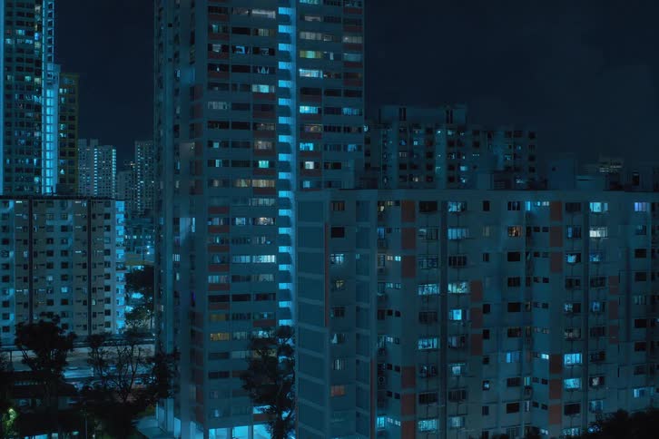 A time lapse of high rise building exteriors at night with windows blinking furiously
