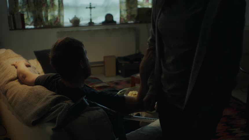 A man is served dinner on the couch