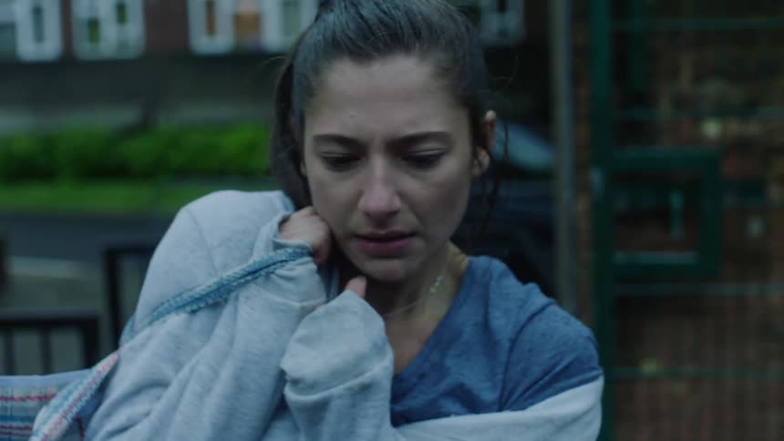 An upset woman being snubbed by a man walking by she picks up a bag and puts it over her shoulder walks away and cries