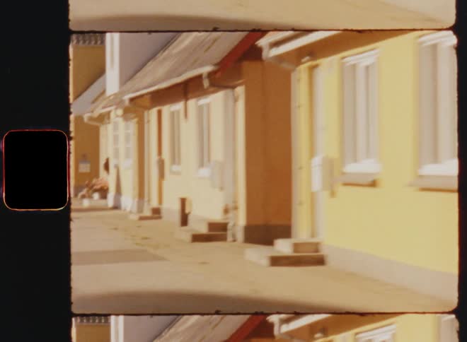 Moving along sidewalk passing residential bungalows during the day