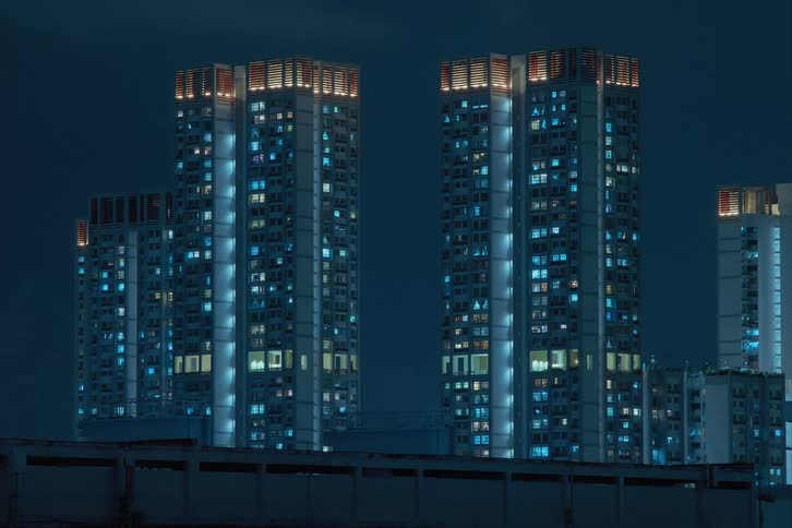 Blue lights flash and flicker inside futuristic towers and buildings in a modern city