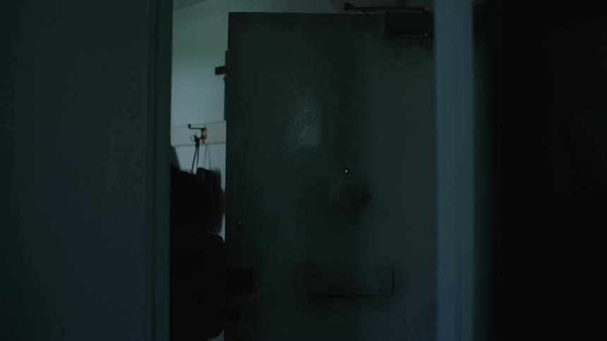 A person is opening a door and walking into their house