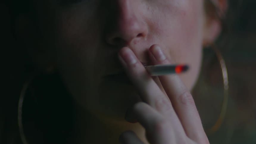 A woman is smoking a cigarette indoors