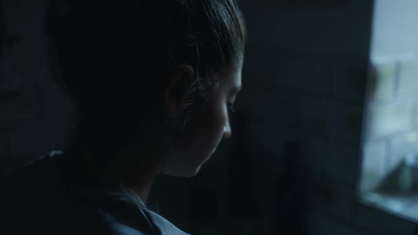 A woman is standing in a room next to a window