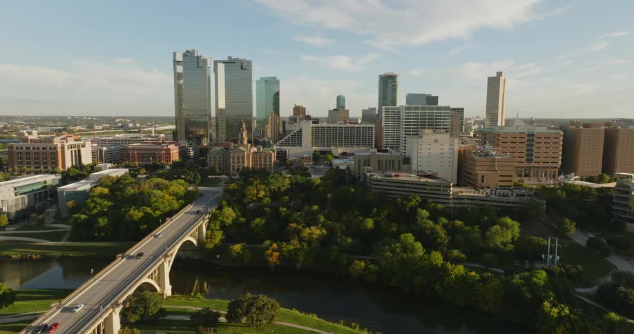 Aerial view of skyscrapers and office buildings and vehicles crossing the bridge in the city