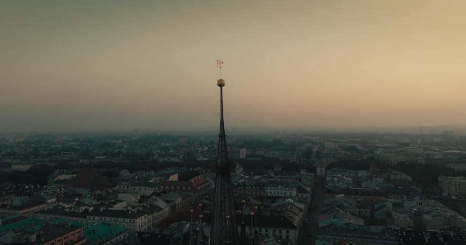 A tall building spire in a city at sunrise