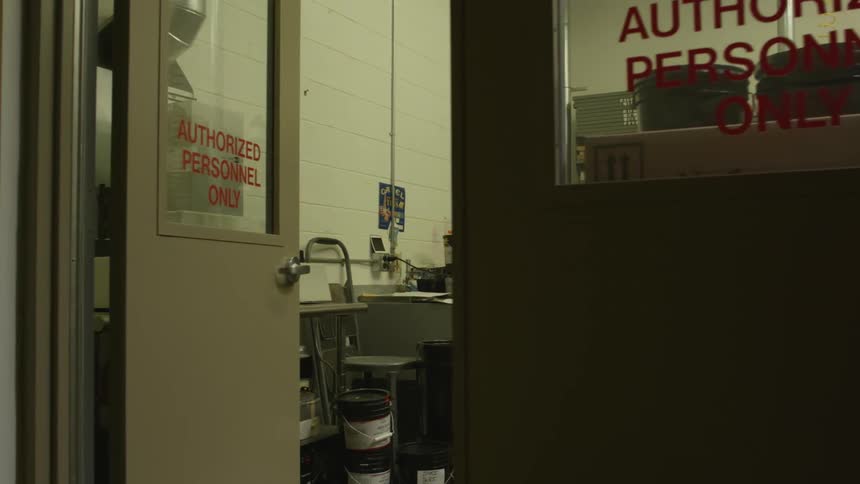 A factory office with the door open showing tools and equipment in the room