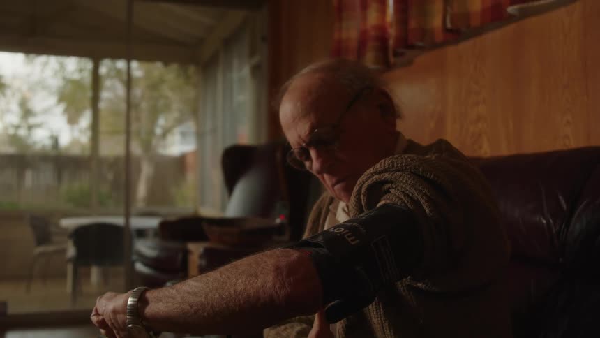 A man is using a blood pressure cuff at home