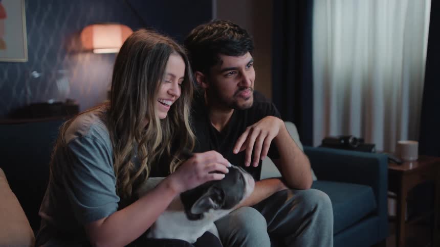A young couple is hanging out with there dog at night time