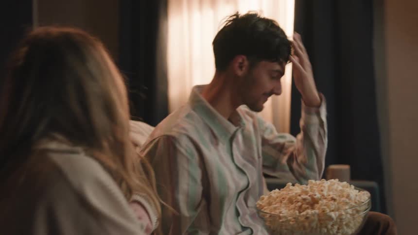 A man throws popcorn into a womans mouth