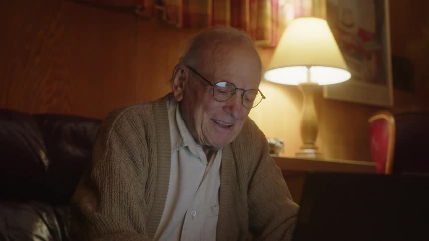 A man smiles while typing on his keyboard