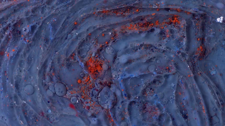 A huge amount of purple liquid with little red crushed rocks in it flows in circles repeatedly