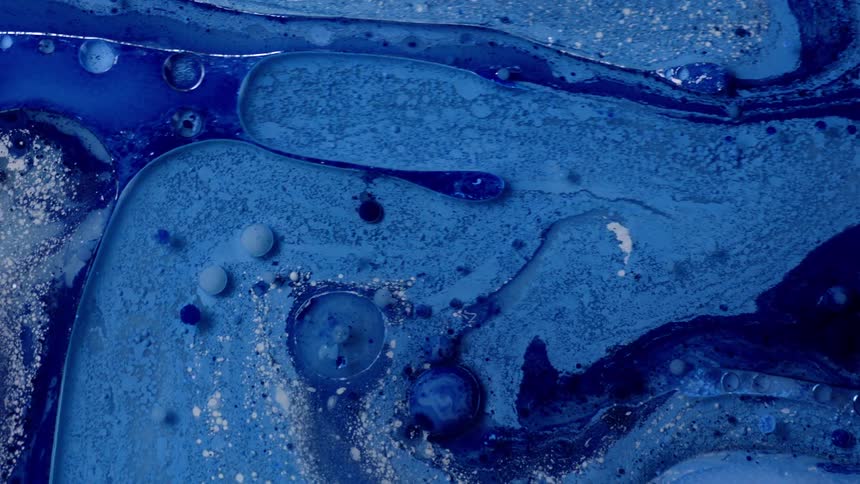 Blue paint being mixed around with a soapy liquid