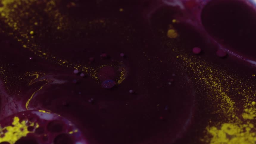 Abstract closeup of swirled paint in burgundy and gold flecks and very light movement